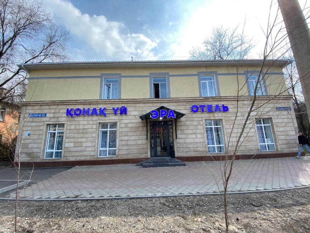 a building with purple signs on the front of it at Отель ЭРА in Almaty