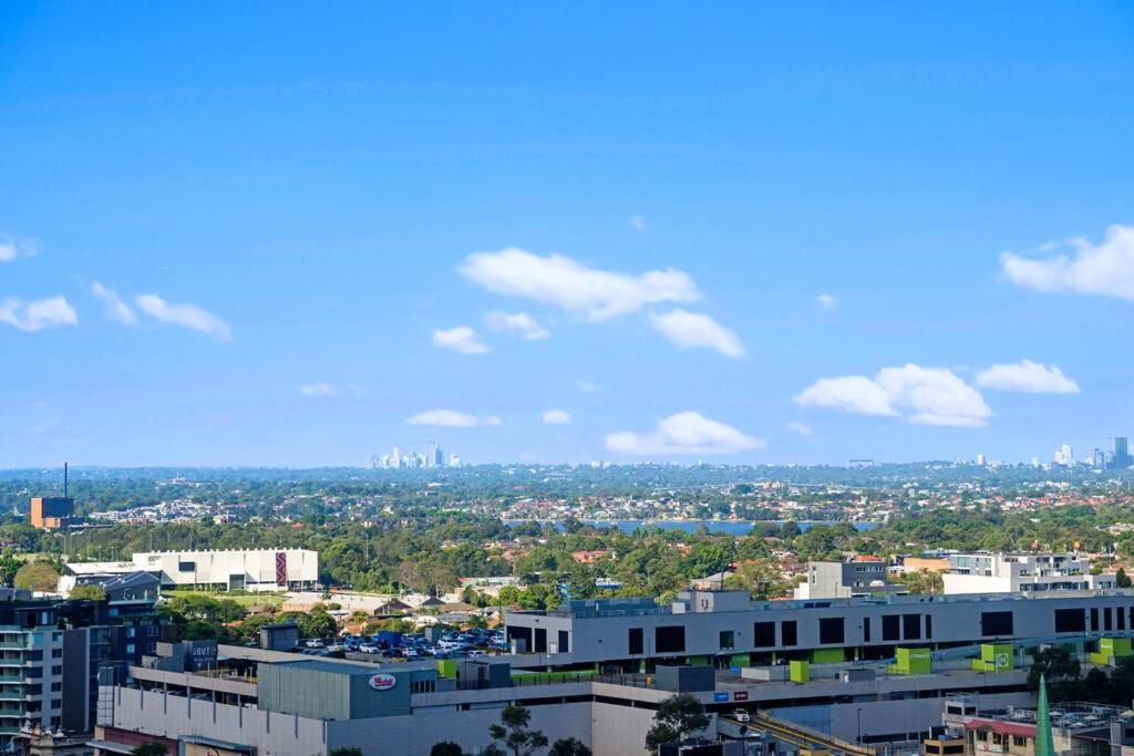a view of a city with buildings and a blue sky at Sky View 2B1B@burwood in Sydney