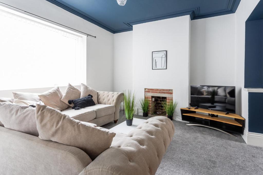 uma sala de estar com um sofá e uma televisão em Homey and Spacious 3 BR house for large group em Blythe