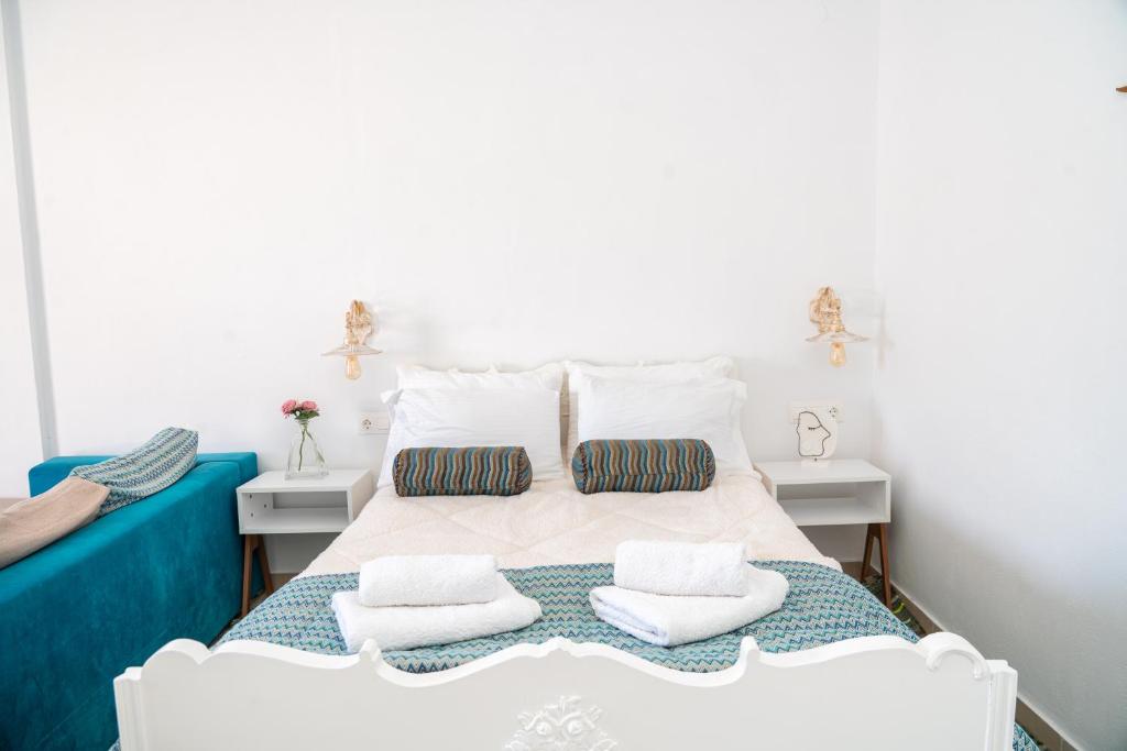 una camera da letto con un letto bianco con due cuscini sopra di Rosalia Studio Megalochori a Megalochori