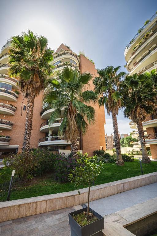 a group of palm trees in front of a building at Galo Luxury House in Rome