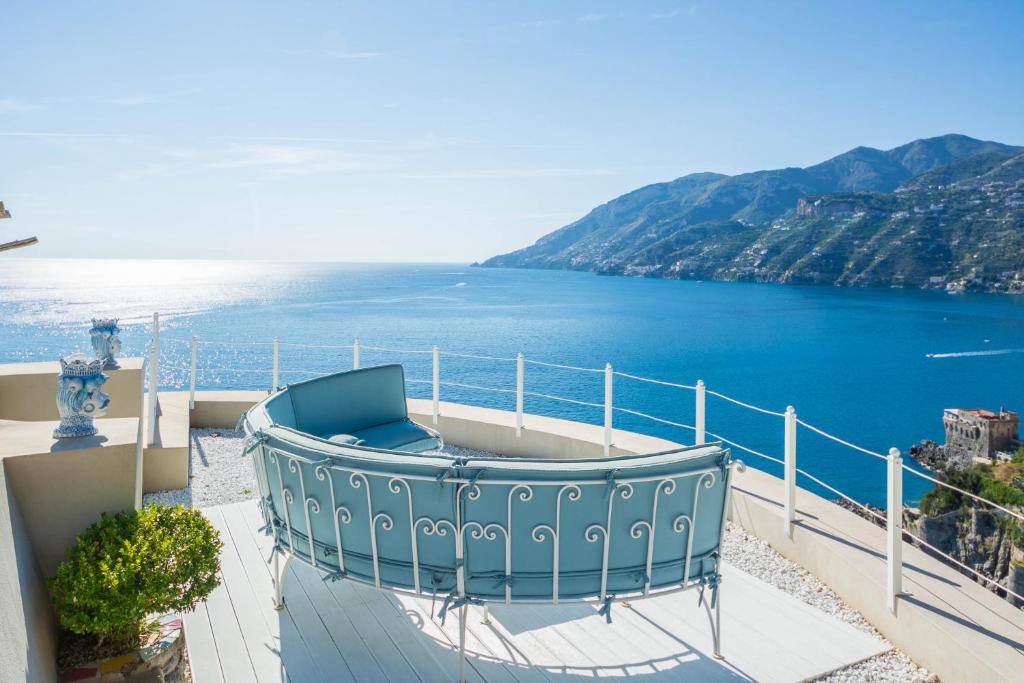 een blauw bad op een balkon met uitzicht op het water bij Villa Venera - pool, jacuzzi & breathtaking view in Maiori