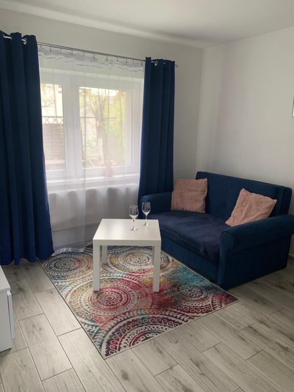 a living room with a blue couch and a coffee table at Apartament pod Zamkiem Chojnik in Jelenia Góra