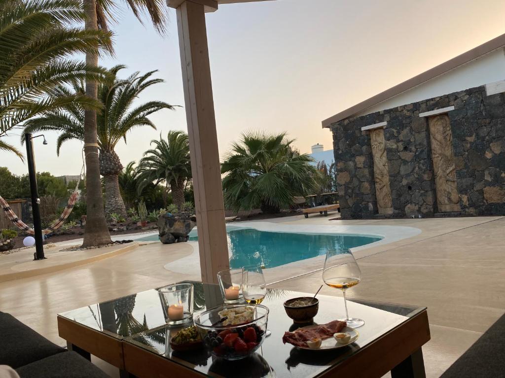 a table with food on it next to a swimming pool at Casa Bagus in Lajares