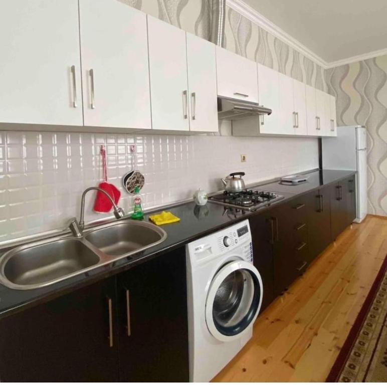 een keuken met een wastafel en een wasmachine bij Rashid in Gabala