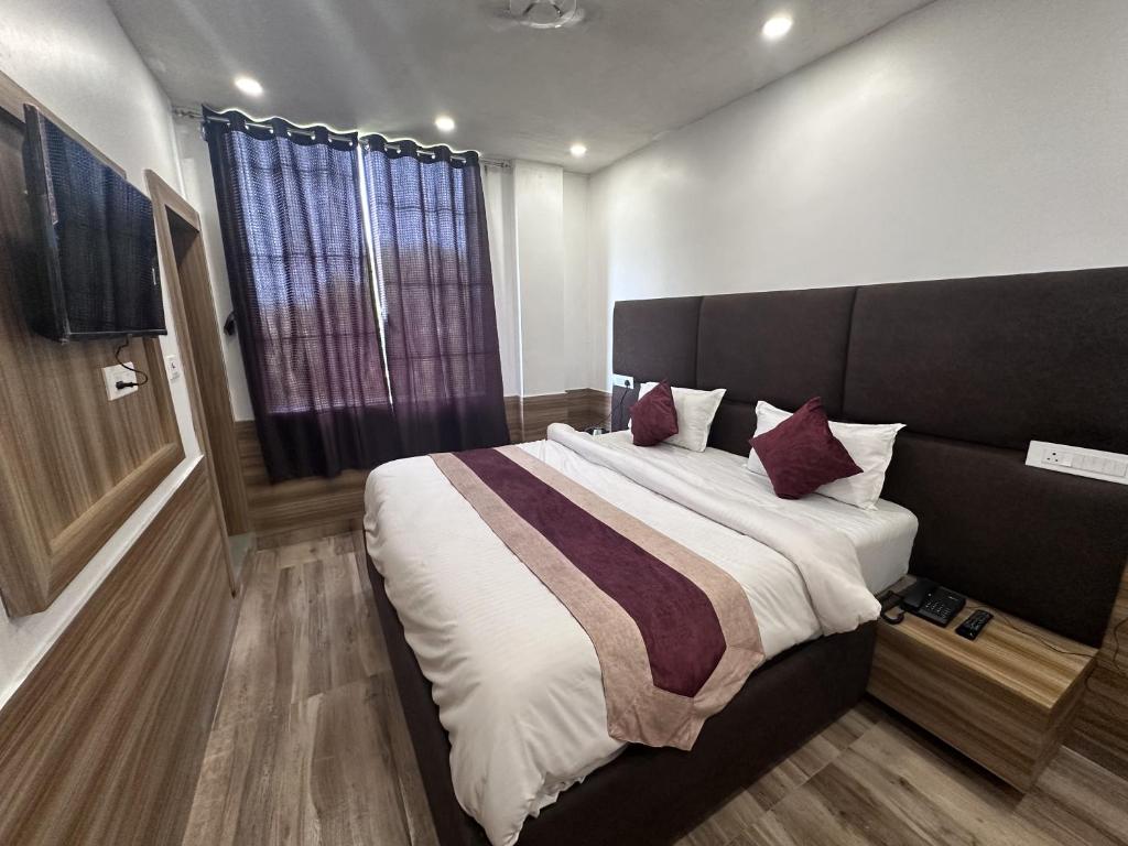 um quarto com uma cama grande e almofadas roxas em Hotel Obsidian Red em Gorakhpur