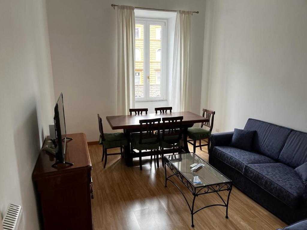 a living room with a table and a blue couch at Be Your Home - MR House in Rome
