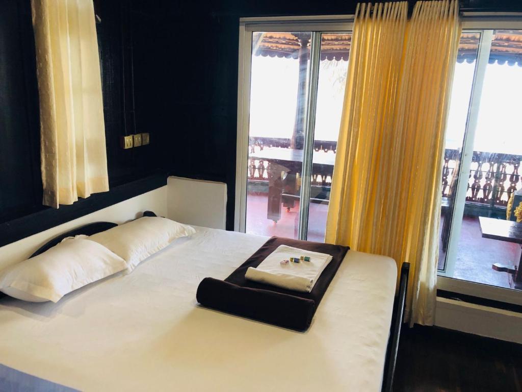 uma cama com uma bandeja em cima num quarto em Timber Monk Beach Resort em Pallipuram