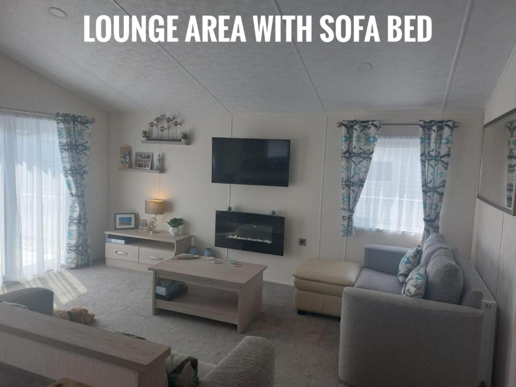 a living room with a couch and a tv at Greenshaw - extremely spacious in Rye Harbour