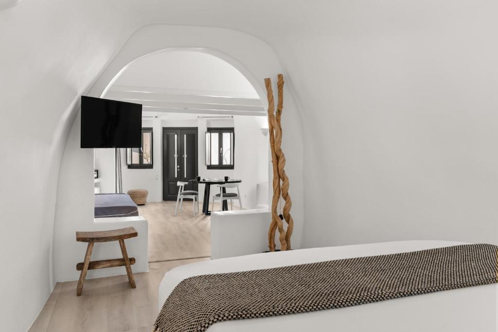 a bedroom with a bed and a living room at Mill Houses New Elegant Suites in Firostefani