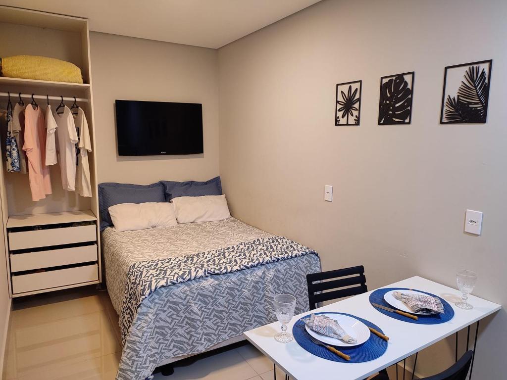 um quarto com uma cama e uma mesa com pratos em Kitnet na melhor localização JD Paulistano em Ribeirão Preto