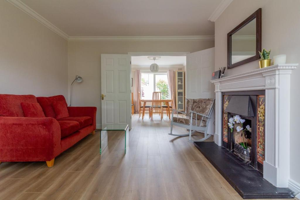 a living room with a red couch and a fireplace at GuestReady - A charming place near Golf Centre in Dublin