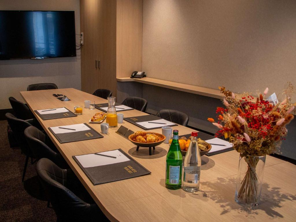 a conference room with a table with a vase of flowers at Mercure Lyon Centre Beaux-Arts in Lyon