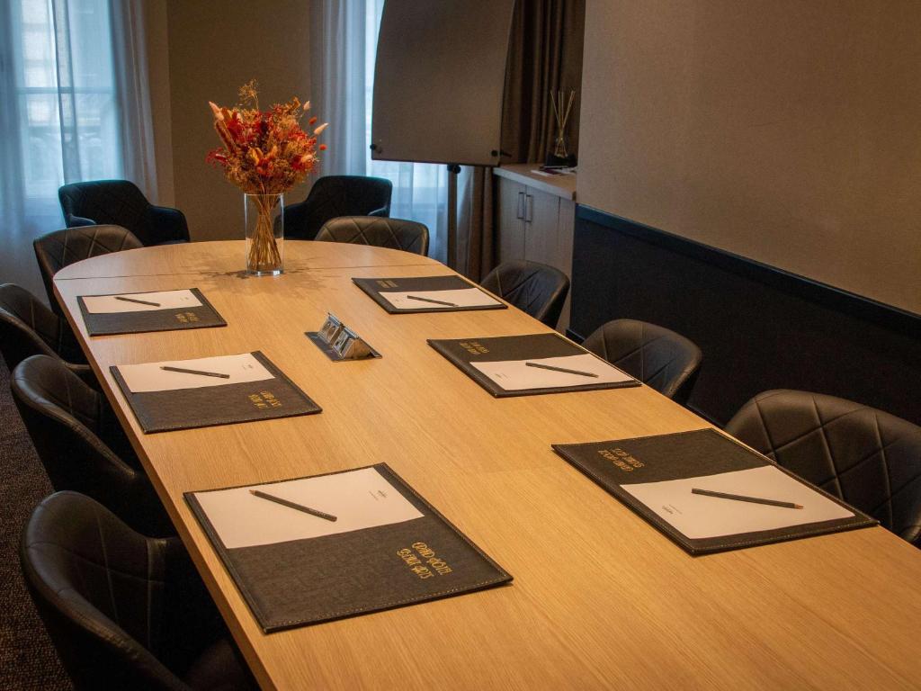 a conference room with a table with a vase of flowers on it at Mercure Lyon Centre Beaux-Arts in Lyon