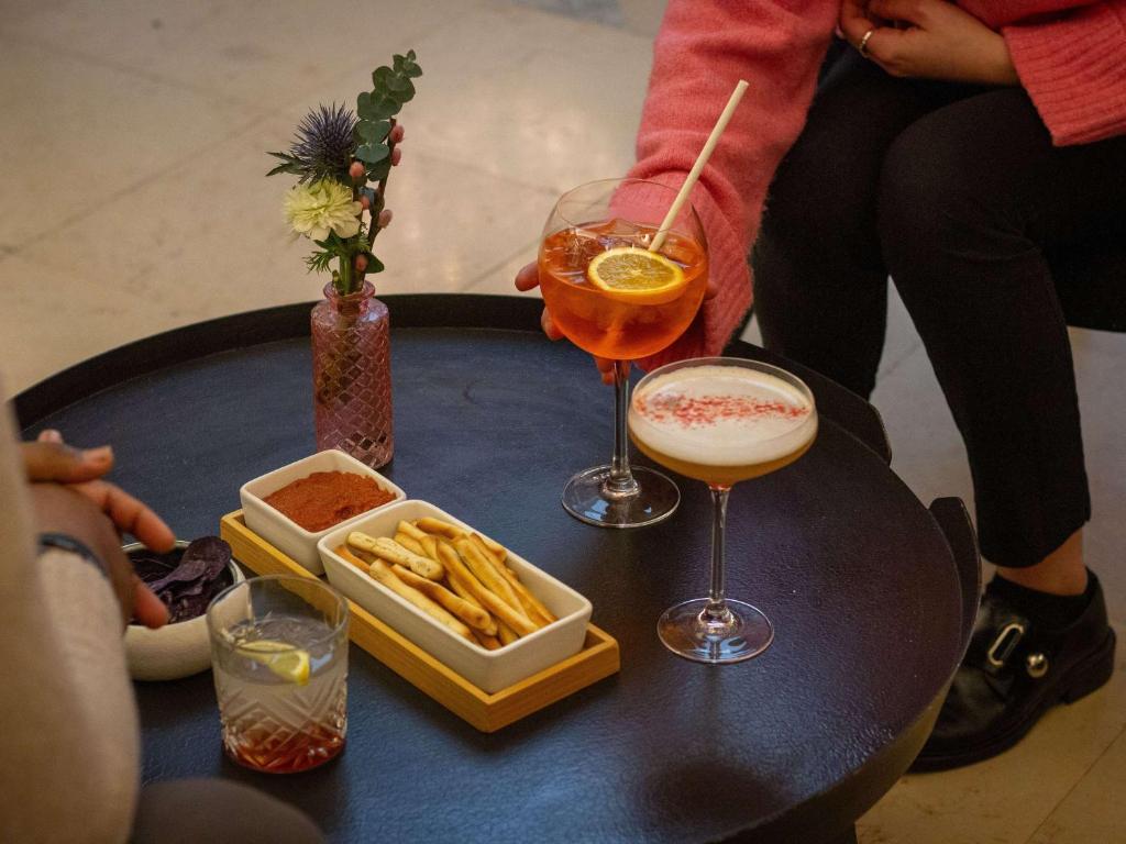 a table with two drinks and a tray of french fries at Mercure Lyon Centre Beaux-Arts in Lyon
