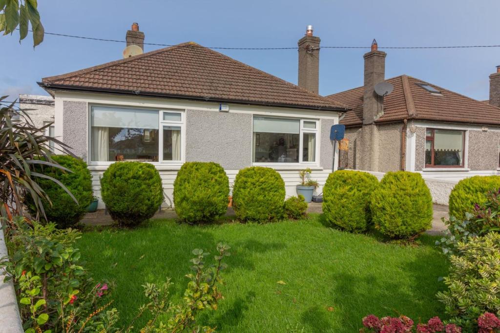 a house with a row of bushes in the yard at GuestReady - Tranquil Retreat in Kimmage in Crumlin