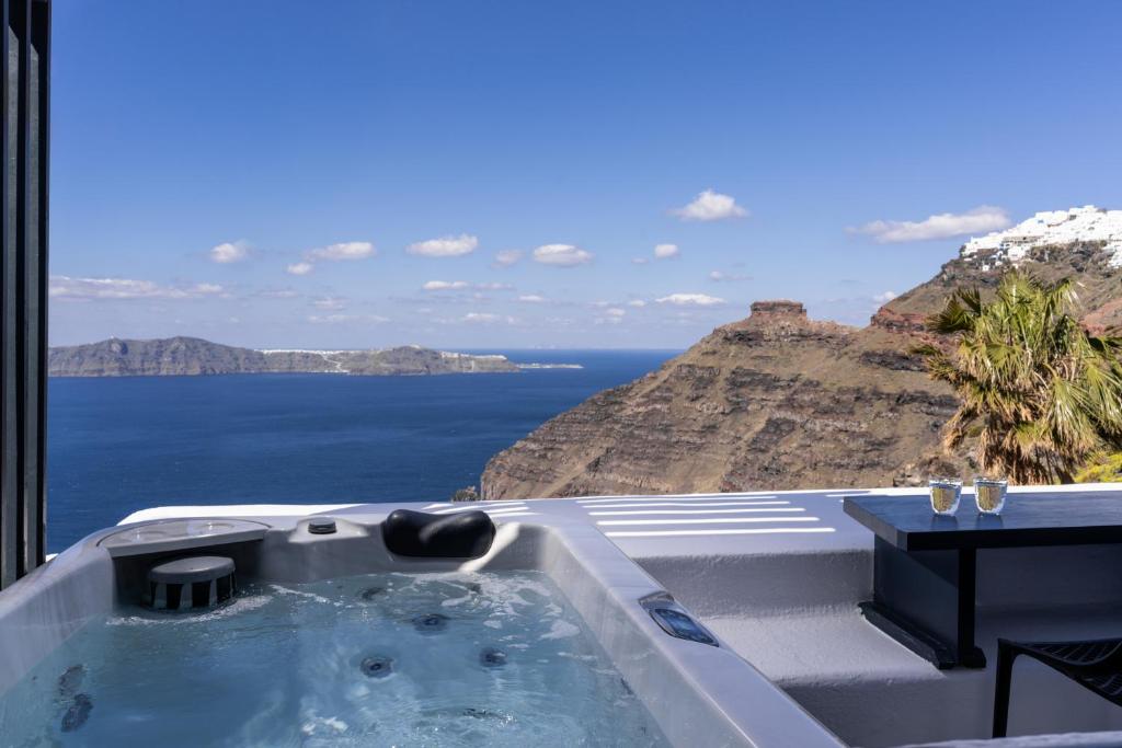 a bath tub with a view of the ocean at Mill Houses New Elegant Suites in Firostefani