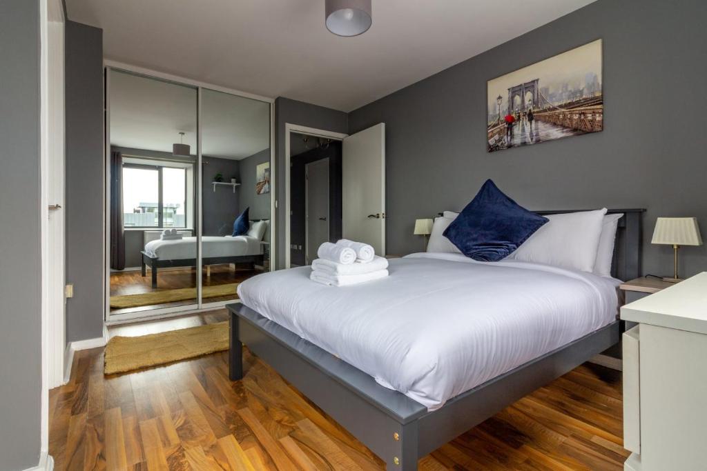 una camera da letto con un grande letto bianco con cuscini blu di GuestReady - Royal Canal Park Chic Getaway a Dublino