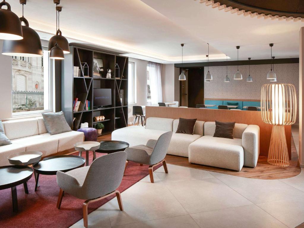 sala de estar con sofá, sillas y mesas en Novotel Suites Colmar Centre en Colmar