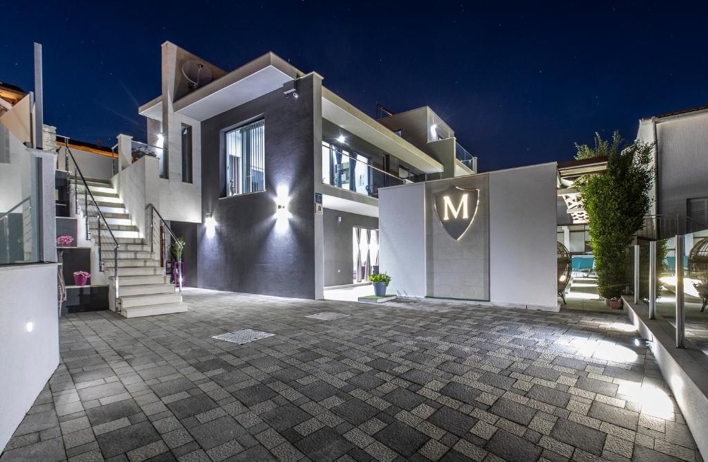 a large white mansion with a m sign on the door at Luxury Villa M in Rogoznica