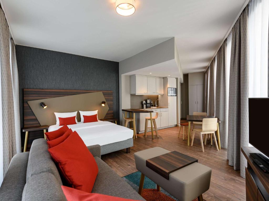 ブレーメンにあるAparthotel Adagio Bremen Cityのベッドとソファ付きのホテルルーム