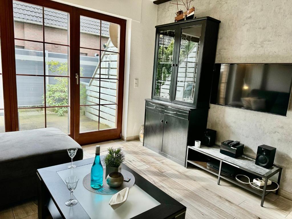 une chambre avec un lit, une table et une télévision dans l'établissement Strandlöper Ferienhaus, à Dangast