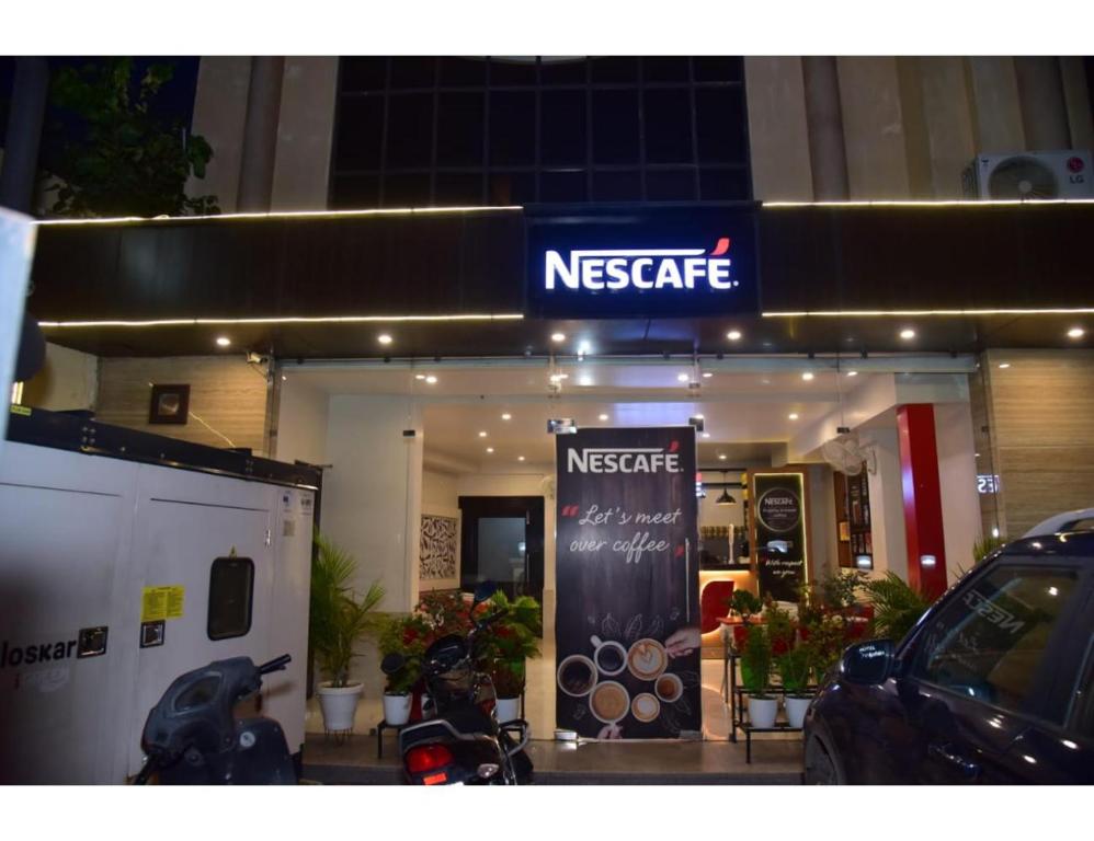 uma loja de café com um carro estacionado em frente em Hotel Dolphin, Udhampur em Udhampur