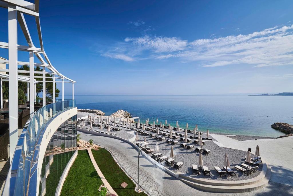 a balcony of a building with chairs and the ocean at Kempinski Hotel Adriatic Istria Croatia in Savudrija