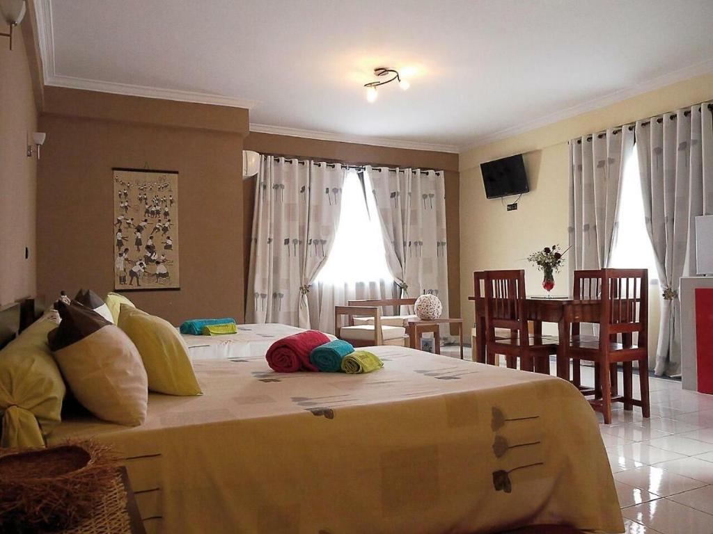 een slaapkamer met een groot bed met kussens erop bij HOTEL LE GRAND PALAIS in Fianarantsoa