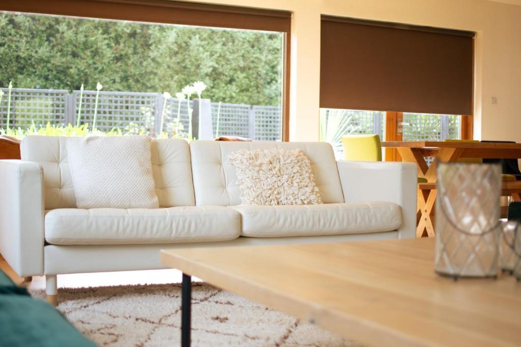 uma sala de estar com um sofá branco e uma mesa em GuestReady - Epitome of Luxury near Shankill Beach em Dublin