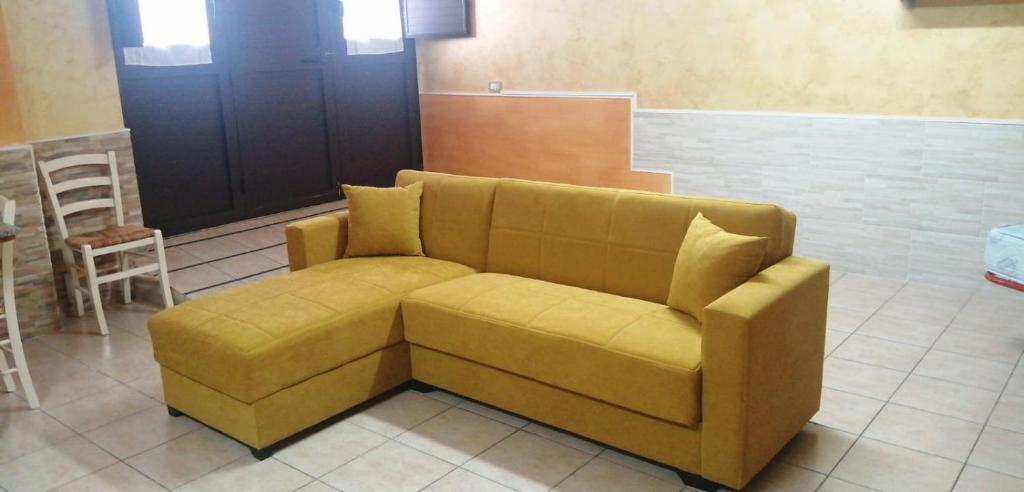 um sofá amarelo num quarto com um bar em Starhouseavola em Avola