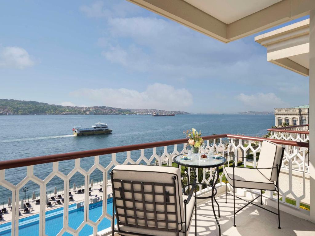 balcón con mesa y sillas y vistas al agua en Çırağan Palace Kempinski Istanbul en Estambul