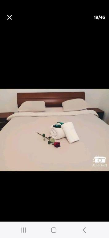 a white bed with two pillows and flowers on it at Anaelle in Birmandreis