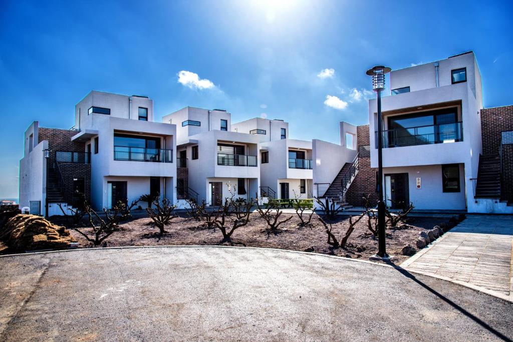 a large white building with trees in front of it at Sanbangsanae Resort in Seogwipo