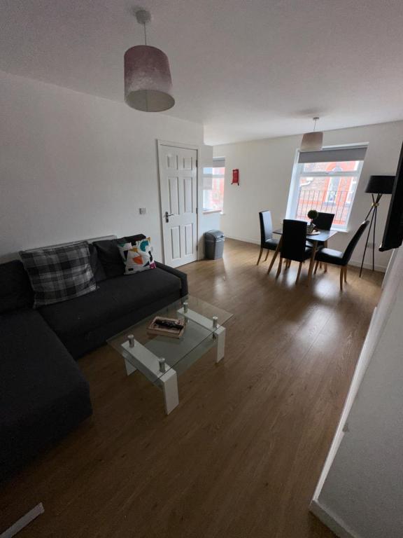 ein Wohnzimmer mit einem Sofa und einem Tisch in der Unterkunft Riverside Relax 1 bedroom near Airport and City Centre PL in Liverpool