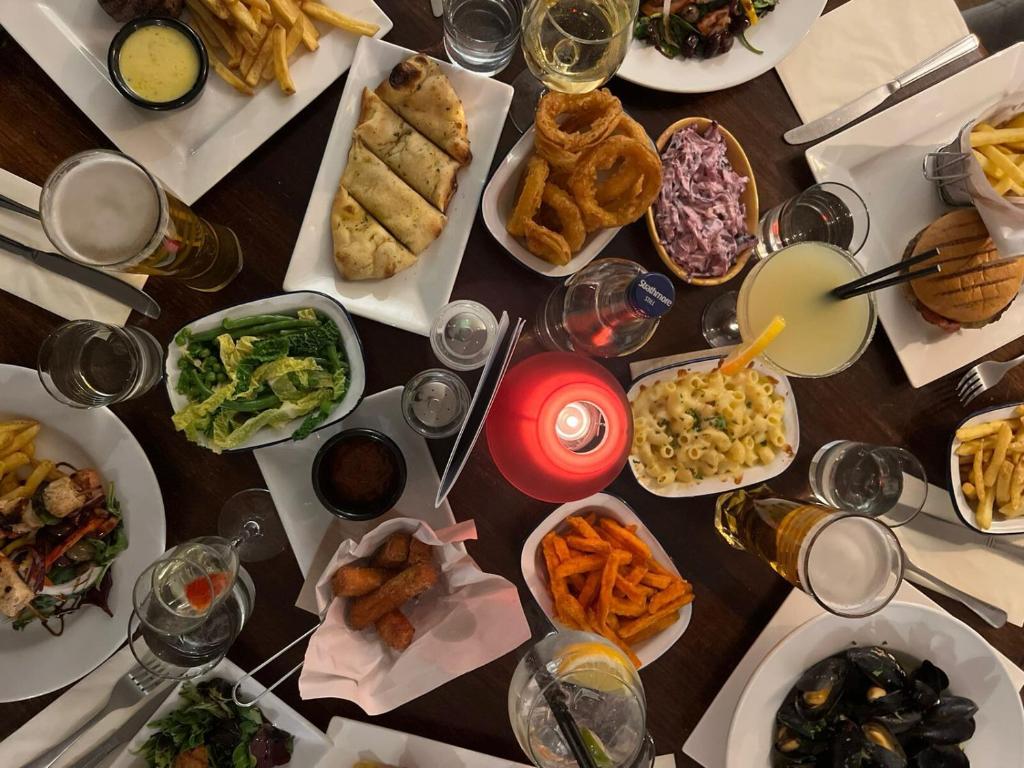 uma mesa com muitos pratos de comida e bebidas em The Squirrel em Godalming