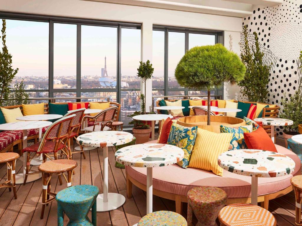 a restaurant with tables and chairs and windows at Mama Shelter Paris La Défense in Puteaux