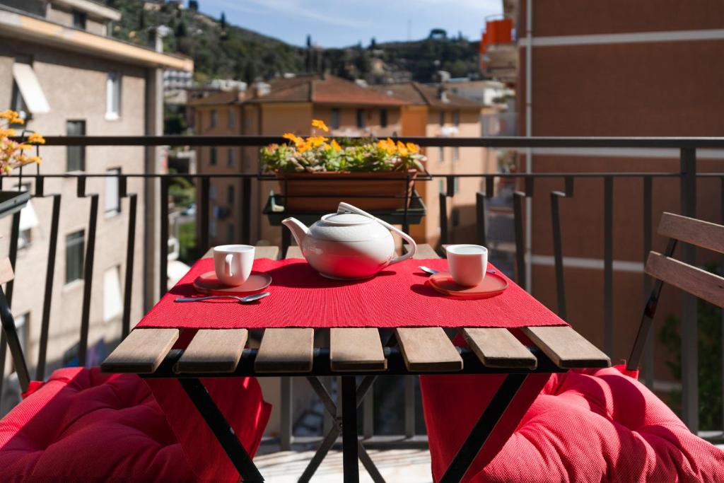 a table with two cups and a tea pot on a balcony at [Free Parking] Un angolo di sole a MareBu! in Rapallo
