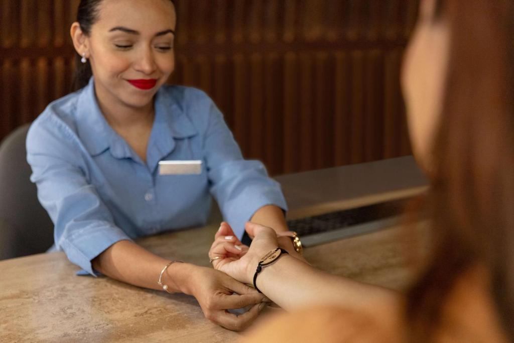 a woman is sitting at a table with her patient at Hilton Cancun Mar Caribe All-Inclusive Resort in Cancún