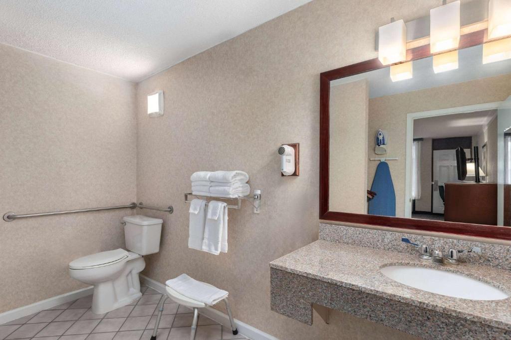 een badkamer met een toilet, een wastafel en een spiegel bij Days Inn by Wyndham Columbia Kentucky in Columbia