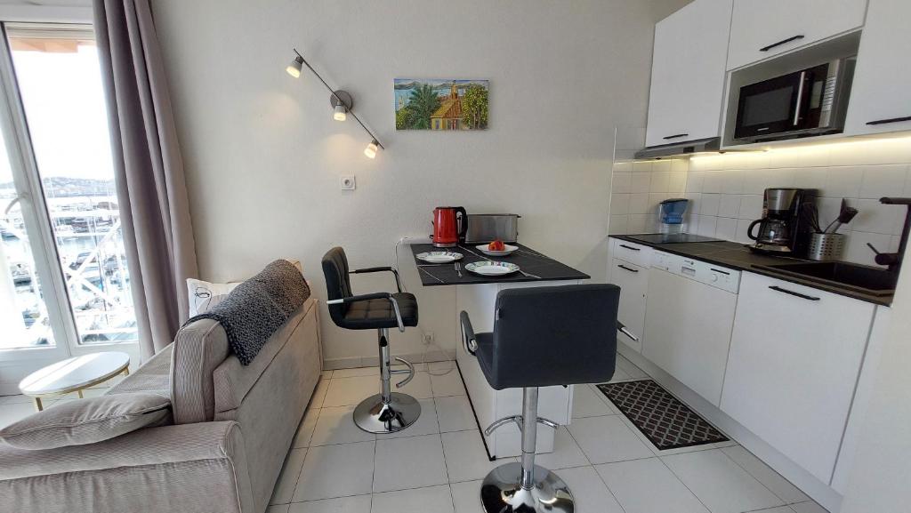 una cucina con divano e tavolo in una camera di Apartment Hirondelle Port Frejus a Fréjus
