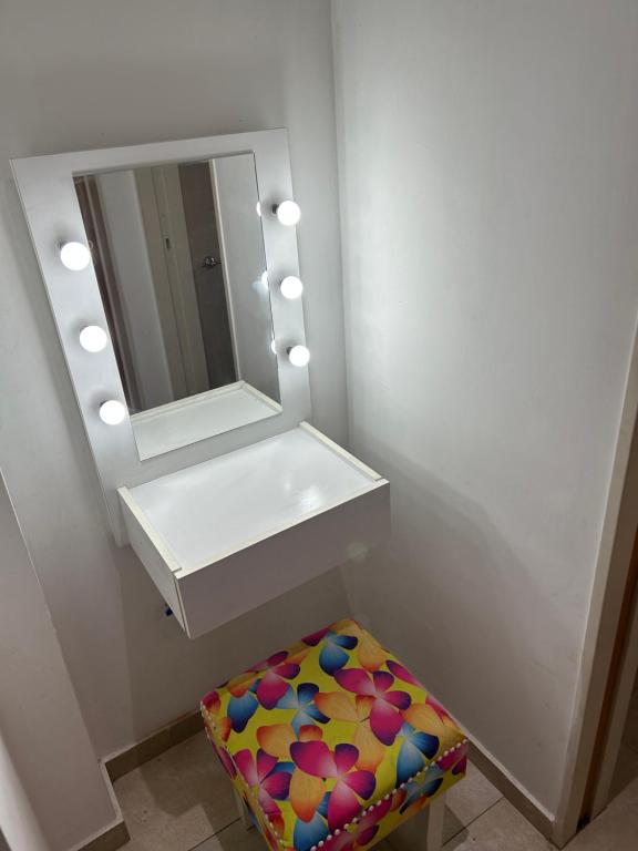 a bathroom with a sink and a mirror and a stool at Depto en Monte Grande a 15 minutos del Aeropuerto 2 Zona Residencial in Monte Grande