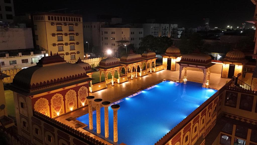 an overhead view of a building with a swimming pool at night at Umaid Haveli-A Heritage Style Hotel & Resort in Jaipur