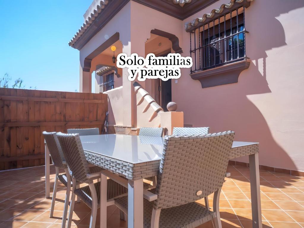 una mesa y sillas en un patio frente a una casa en Casa con Terraza Privada cerca del Pueblo para familias A, en Conil de la Frontera