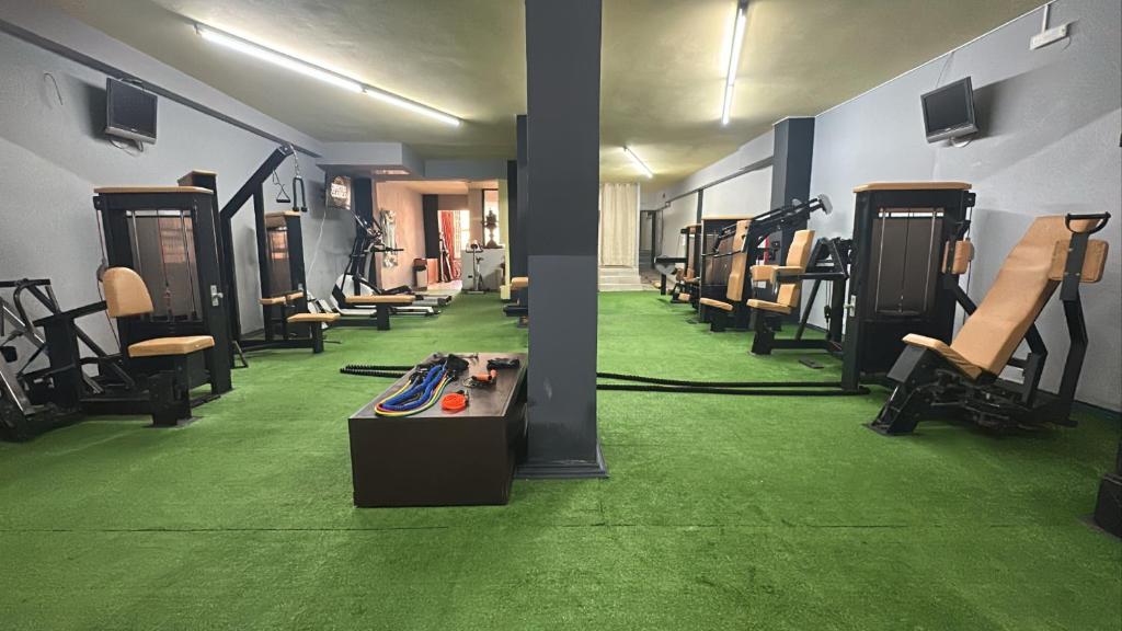 a room with a gym with green floors and chairs at Thalia deco City & Beach Hotel in Hersonissos