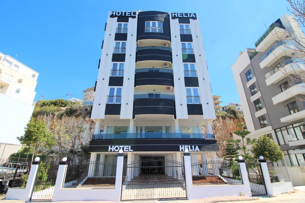 un hotel con un cartel en la parte delantera en Helia Hotel en Sarandë