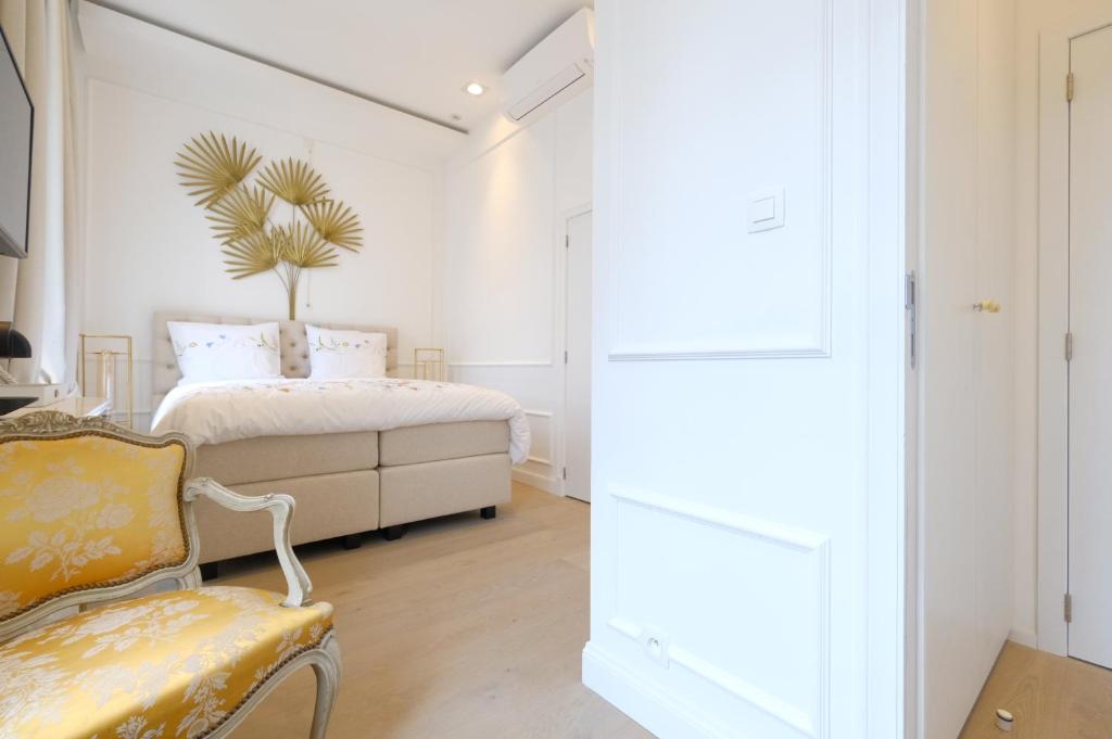 モンスにあるRoom Jade - La Maison de la duchesse de la Valliere - Parking privéのベッドと椅子のある白い寝室