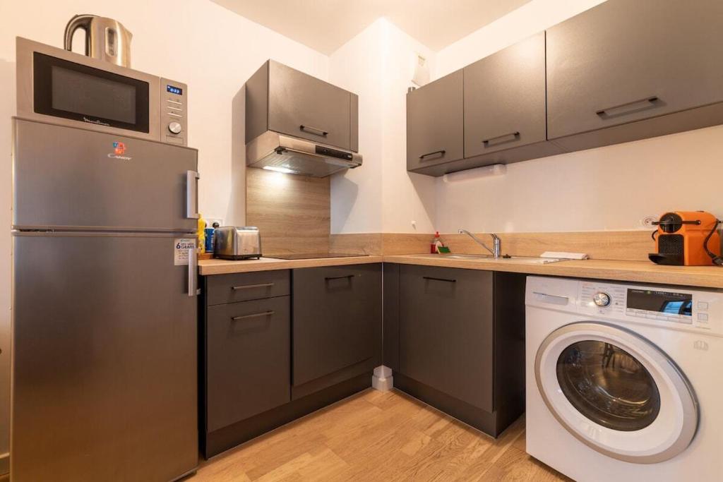 een keuken met een koelkast en een wasmachine bij Coeur urbain - centre historique in Montpellier