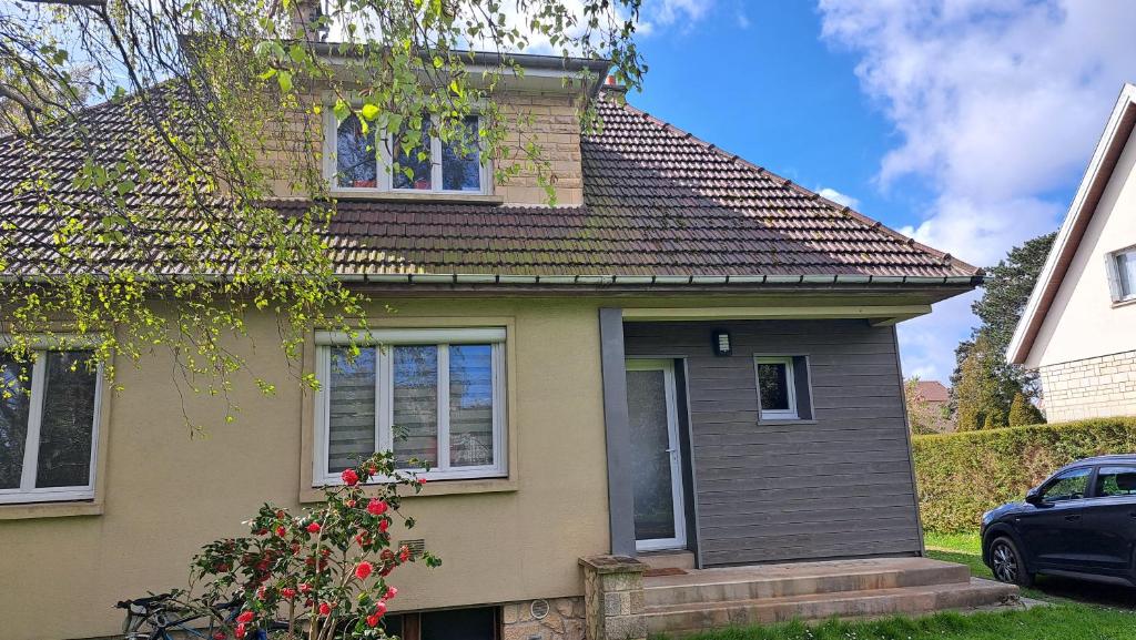 une maison avec toit et une voiture garée devant dans l'établissement Maison proche plages du Débarquement, à Douvres-la-Délivrande