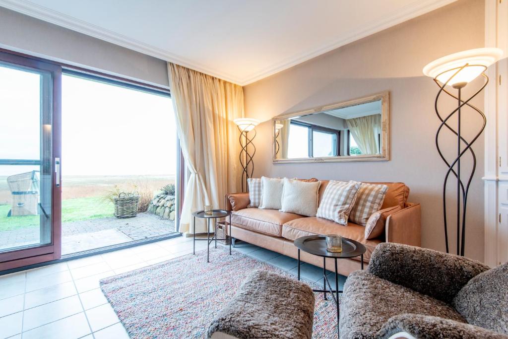 a living room with a couch and a table at Ferienwohnung Feskerdam in Morsum